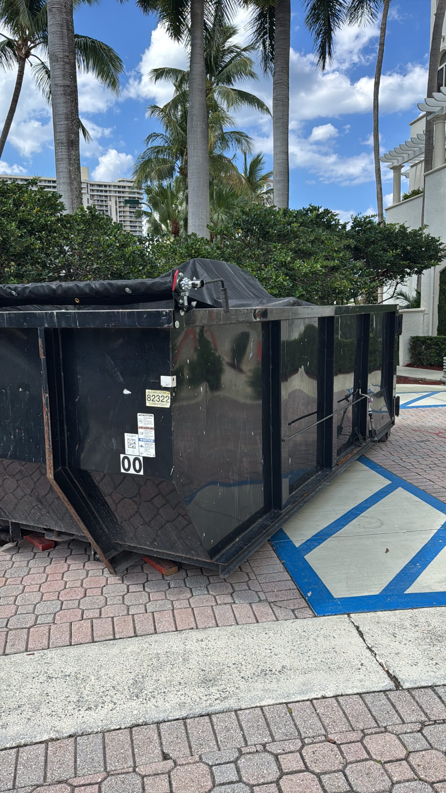 Black roll-off dumpster staged for debris haul-off