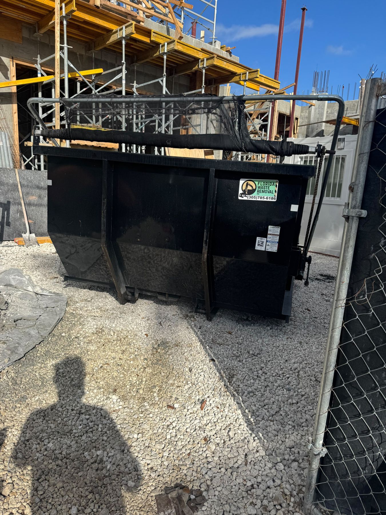 Florida Waste Removal branded dumpster at a construction site